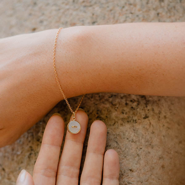 bracciale catenina oro giallo piccolo ciondolo bottoncino madreperla bianca made in italy