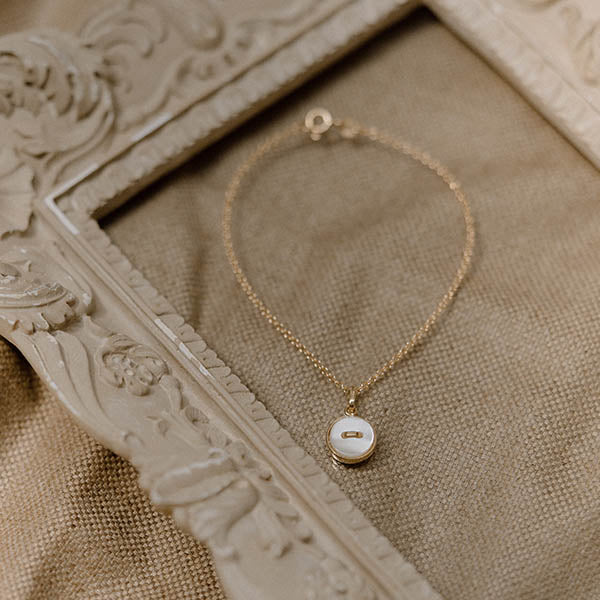 bracciale catenina oro giallo piccolo ciondolo bottoncino madreperla bianca made in italy