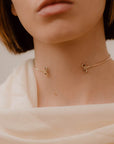 ragazza indossa collana girocollo sottile aperta davanti oro giallo ghirigori made in italy